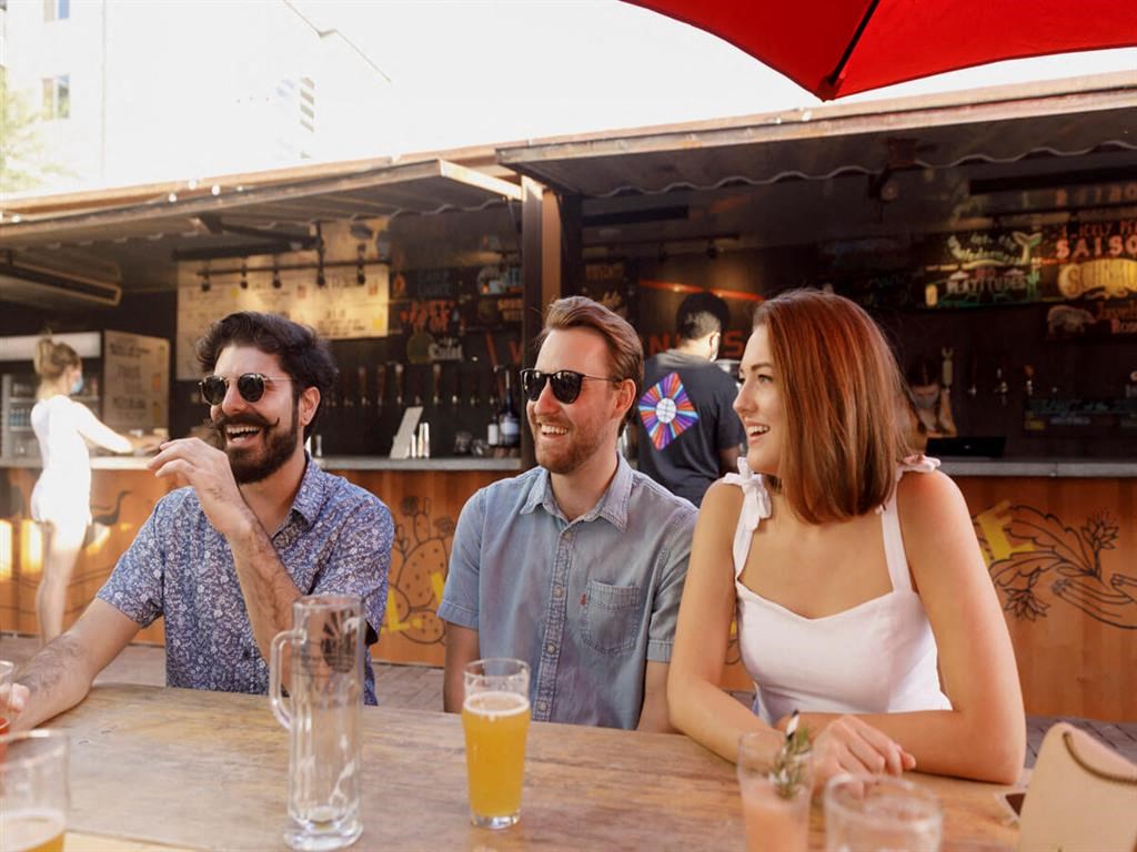 three people sitting at a table with drinks