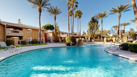A swimming pool surrounded by palm trees and buildings.