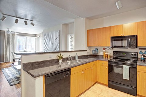 A kitchen with wooden cabinets and a black oven.