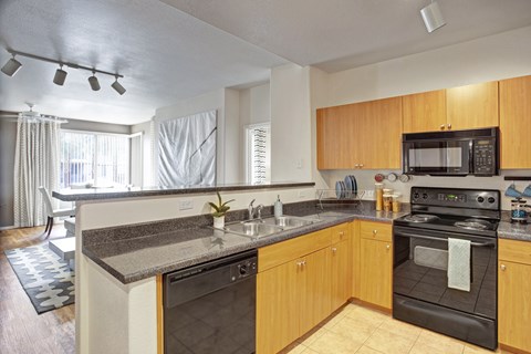 A kitchen with wooden cabinets and a black oven.
