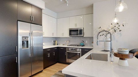 A modern kitchen with a stainless steel refrigerator and white countertops.