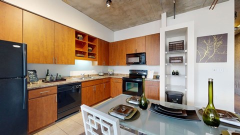 A kitchen with wooden cabinets and a black refrigerator.