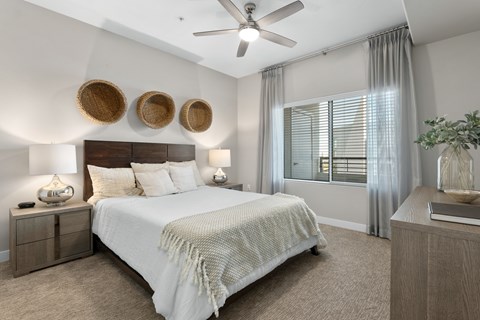 A bedroom with a large bed and a ceiling fan.