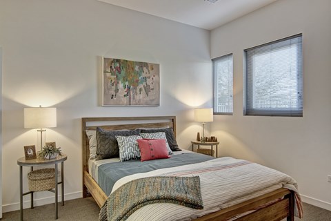 A bedroom with a large bed and a painting on the wall.