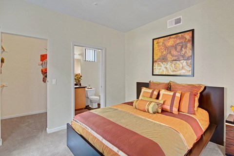 A bedroom with a large bed and a painting on the wall.