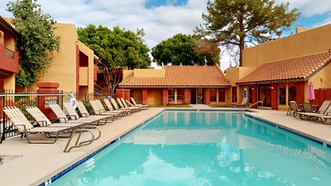A pool with chairs around it and a sign that says "quiet" in the background.