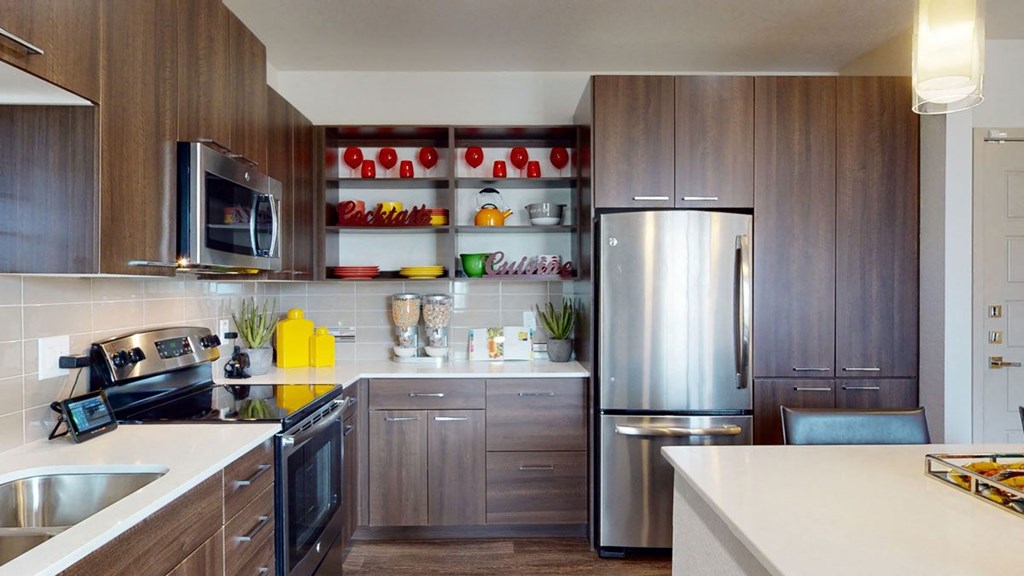 a kitchen with wooden cabinets and a stainless steel refrigerator