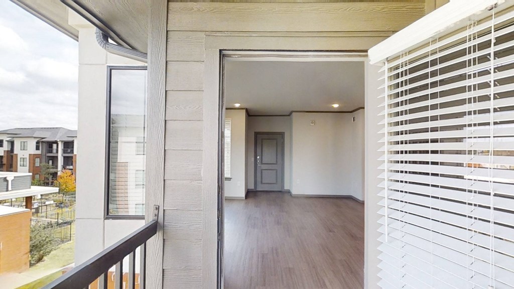 the view of the hallway from the balcony of a home with white shuttered windows