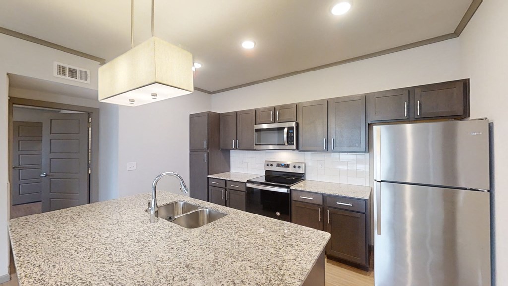 a kitchen with stainless steel appliances and granite counter tops