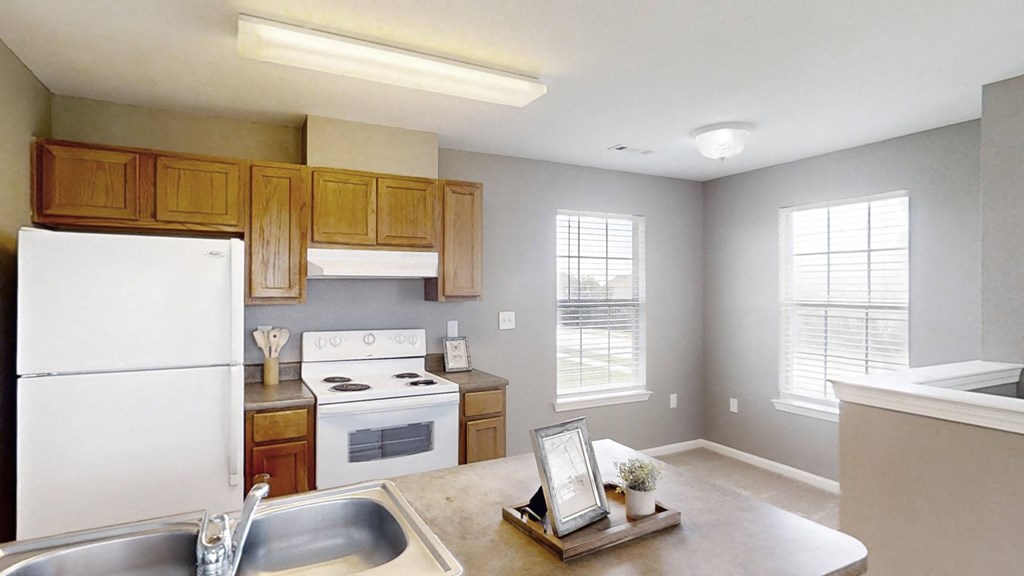 A kitchen with white appliances and wooden cabinets