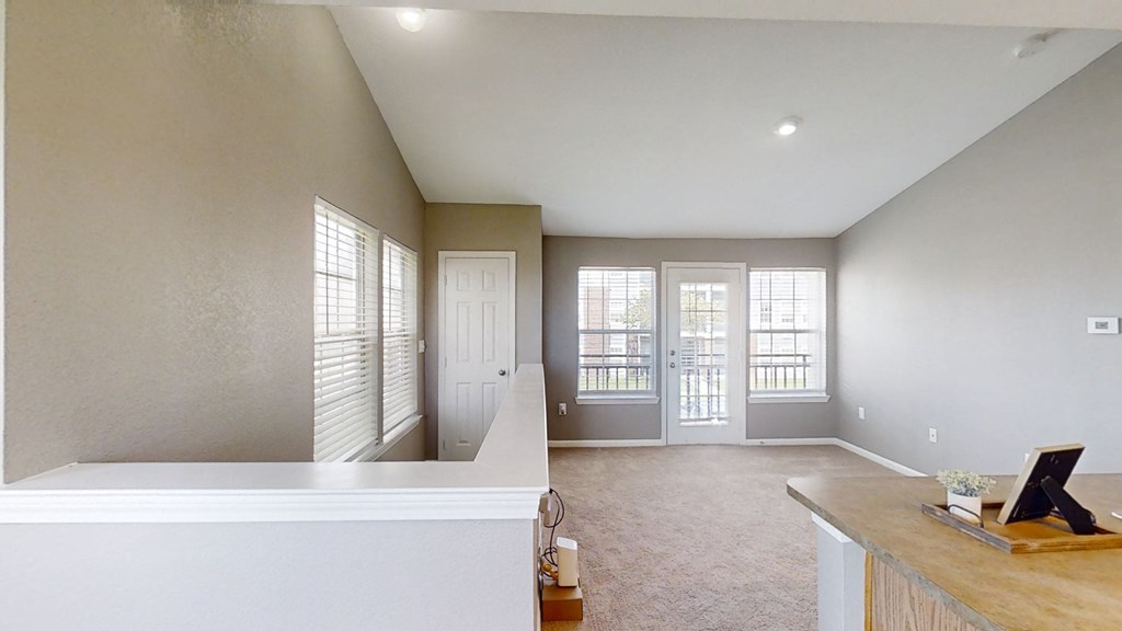 Large living room with a staircase and a door to a balcony