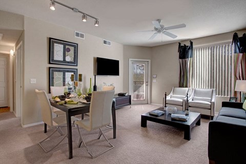 a living room and dining room with a table and chairs