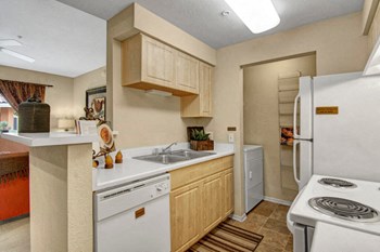 A kitchen with cabinets and white appliances Retreat at Speedway Kitchen - Photo Gallery 4