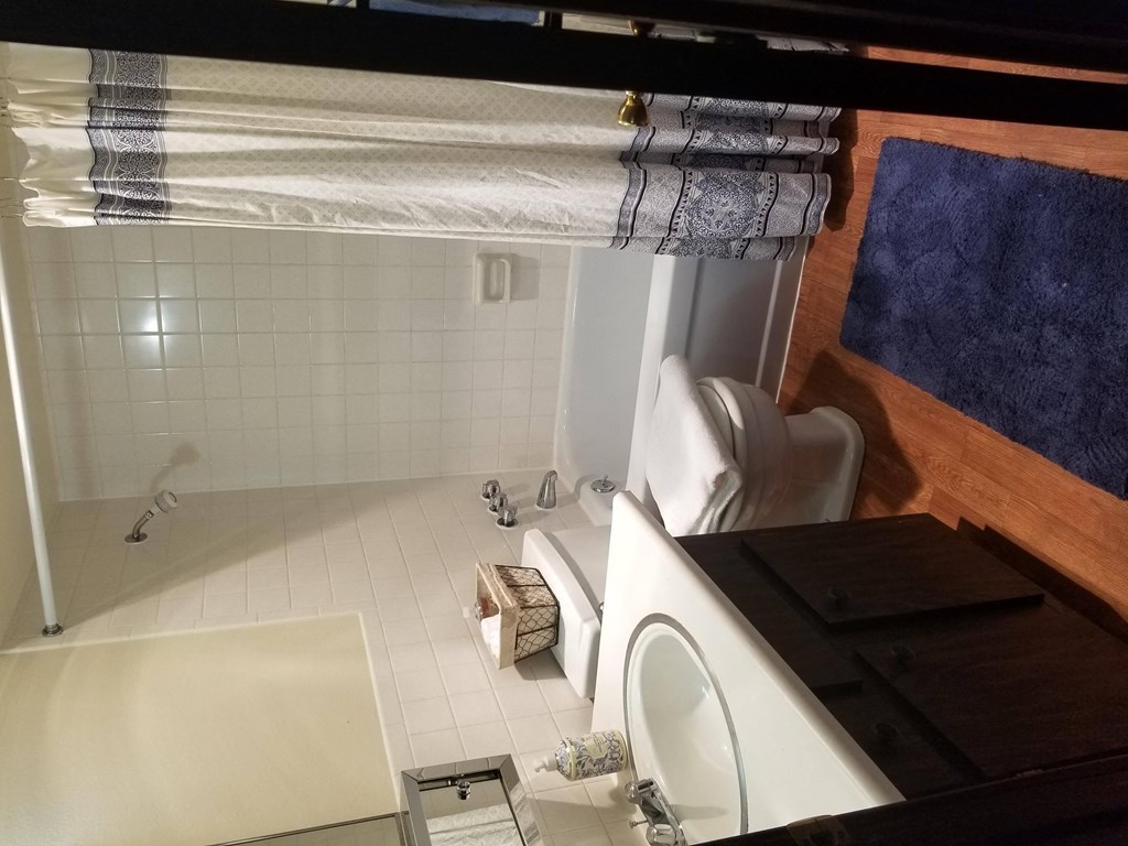 A bathroom with a white tub and a white toilet.