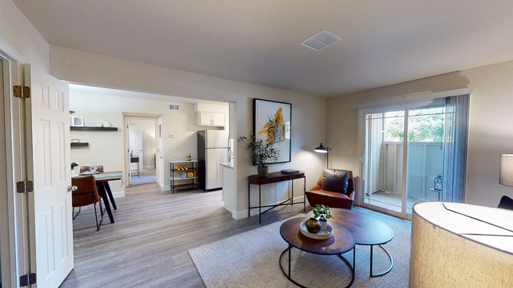 a living room with a sliding glass door leading to a kitchen