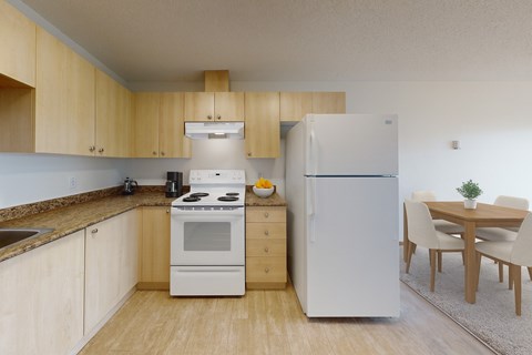 A kitchen with a white stove and refrigerator, wooden cabinets, and a dining table with chairs.