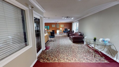 A living room with a red carpet and a glass coffee table.