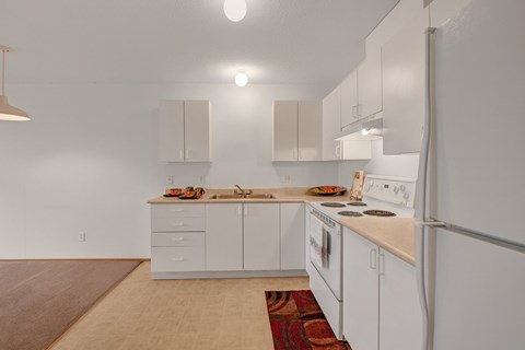 A kitchen with white cabinets and appliances.