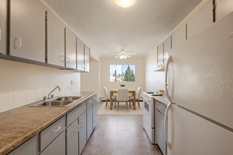 A kitchen with a table and chairs in the background.