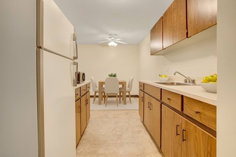 A kitchen with wooden cabinets and a white refrigerator.