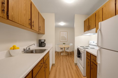 A kitchen with wooden cabinets and white appliances.