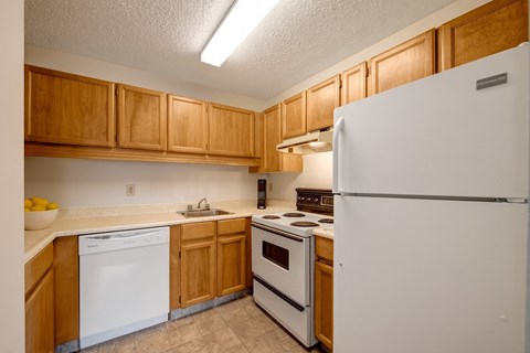 A kitchen with wooden cabinets and white appliances.