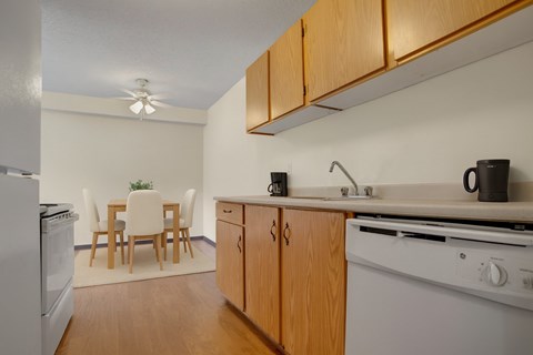 A kitchen with wooden cabinets and a white stove top oven.