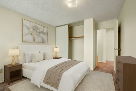 A bedroom with a large bed and two lamps.