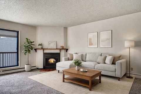 A living room with a fireplace, couch, and pictures on the wall.