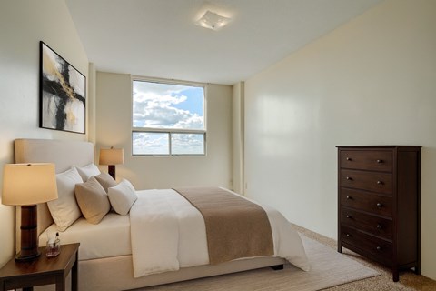 A bedroom with a large bed and a dresser.