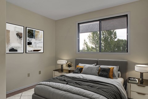 A bedroom with a large bed and two lamps.