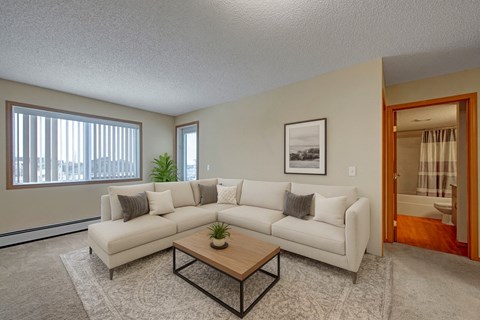 A living room with a white couch and a coffee table.