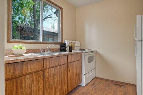 A kitchen with wooden cabinets and a white refrigerator.