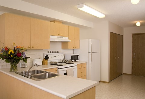 A kitchen with wooden cabinets and a white refrigerator.