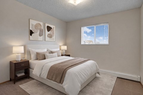 A bedroom with a large bed and two wall lamps.