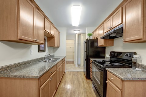 A kitchen with wooden cabinets and black appliances.