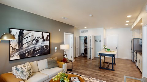 A living room with a couch, a coffee table, and a painting on the wall.