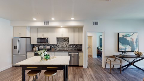 A modern kitchen with a dining table and chairs.