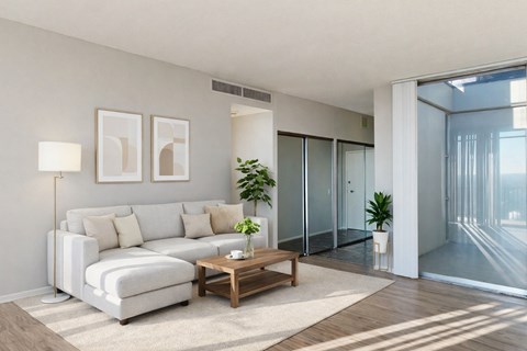 A modern living room with a white sofa, a wooden coffee table, and a plant.