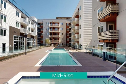 A swimming pool in the middle of a courtyard surrounded by apartment buildings.