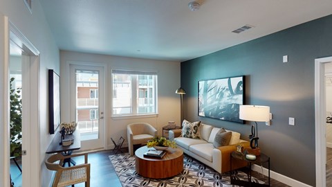 A living room with a couch, coffee table, and a painting on the wall.