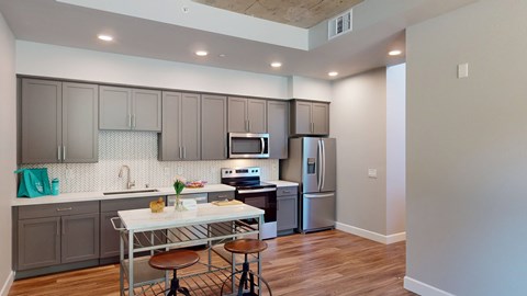 A kitchen with a table and chairs in front of a refrigerator.