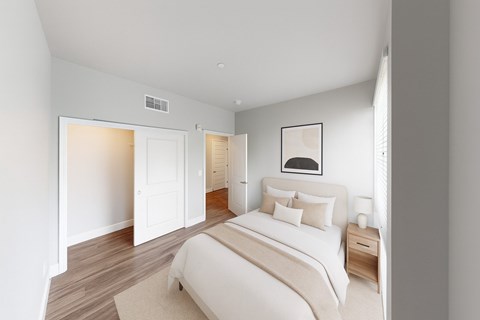 A bedroom with a large bed and a nightstand.