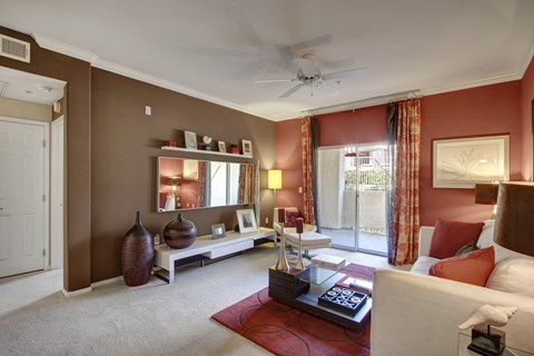 A living room with a white couch and a red rug.