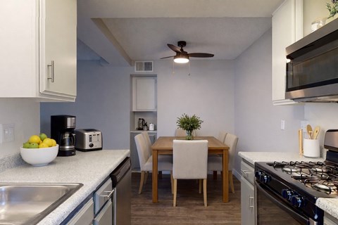 A kitchen with a table and chairs in the middle.