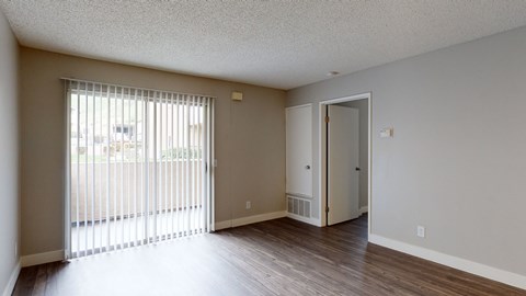 A room with a sliding glass door and a white door.