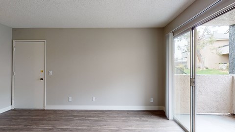 A room with a white door and a window with a view of a building outside.