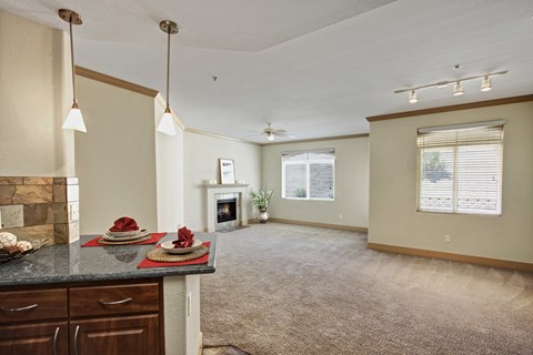 A living room with a fireplace and a dining table set for two.