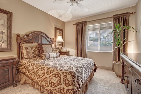 A bedroom with a large bed and a ceiling fan.