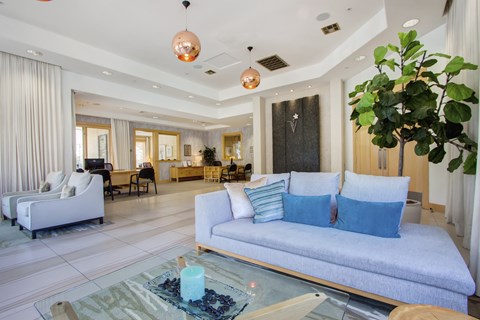 A modern living room with a white sofa and a glass coffee table.